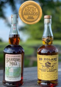 Pictures of 750mL bottles of Barker's Mill Bottled in Bond Bourbon and MB Roland Kentucky Straight Corn Whiskey with Ascot Awards Gold Winner logo in top center